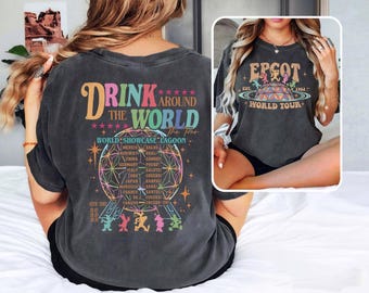 Könnte beinhalten: Ein schwarzes T-Shirt mit einer Grafik im Vintage-Stil der Epcot World Showcase Lagoon. Die Grafik enthält den Text "Drink Around the World" und eine farbenfrohe Illustration des ikonischen Epcot-Globus mit den Namen der Länder drumherum. Der Text "The Four" ist ebenfalls enthalten. Die Rückseite des Shirts zeigt den Text "Epcot Est. 1982 World Tour" mit einer Grafik der Epcot-Charaktere.