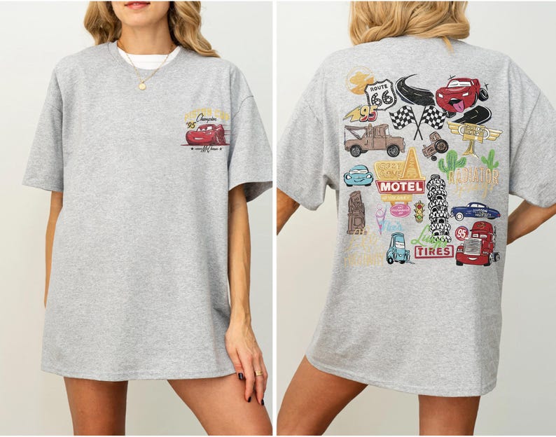 May include: A light gray t-shirt featuring a cartoon image of a red race car on the front and a collage of car-themed graphics on the back. The shirt has short sleeves and a crew neck.