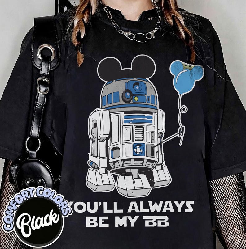May include: Black t-shirt featuring a graphic of R2-D2 with Mickey Mouse ears and a blue balloon. The text "YOU'LL ALWAYS BE MY BB" is printed in white. The shirt has a Comfort Colors label.