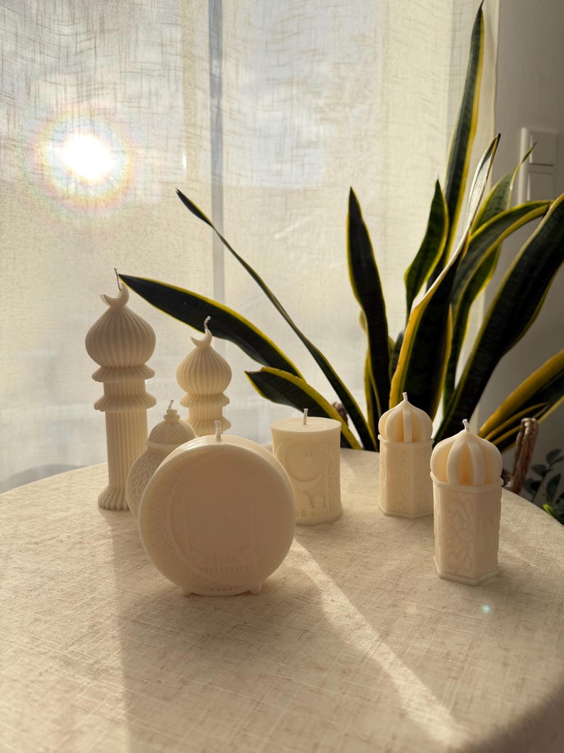 Puede incluir: Una colecci&oacute;n de velas de color marfil en varias formas, incluyendo dise&ntilde;os cil&iacute;ndricos, en forma de c&uacute;pula y de pilar. Algunas velas presentan patrones intrincados y detalles arquitect&oacute;nicos, creando un ambiente c&aacute;lido y acogedor. Las velas est&aacute;n dispuestas sobre una superficie de tonos neutros.