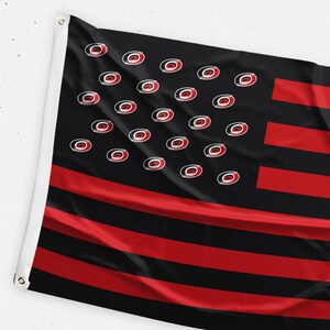 May include: A black and red American flag with a stylized "O" logo in place of the stars. The flag is made of fabric and is slightly wrinkled.