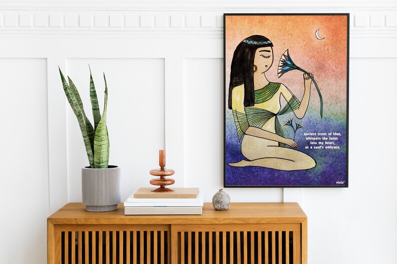 May include: A watercolor illustration of a woman with long black hair wearing a yellow and green dress, holding a blue and yellow lotus flower. The background is a gradient of orange, yellow, and purple. The text "Ancient scent of Man, whispers the lotus into my heart, in a soul's embrace." is written in the bottom right corner.