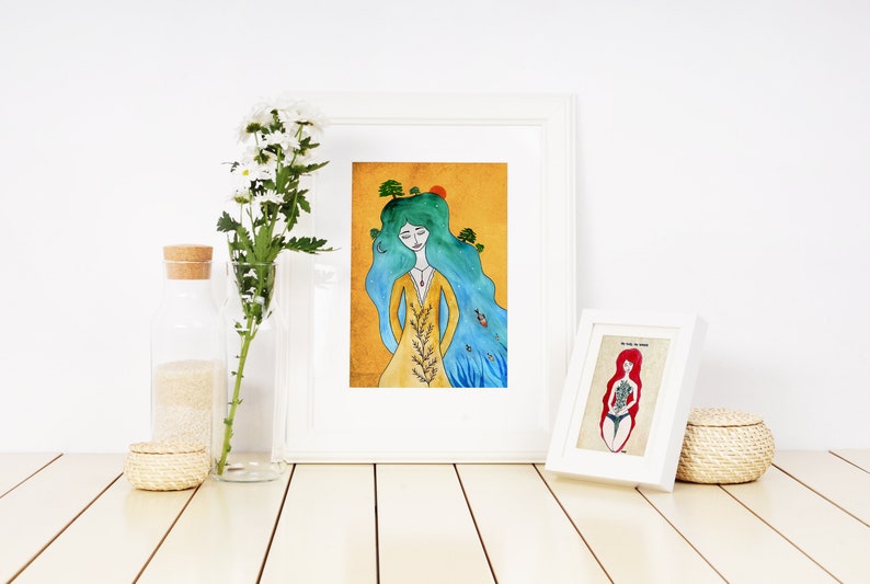 May include: Two framed watercolor illustrations of women with long hair. The first illustration features a woman with blue hair and a yellow dress, with trees growing from her hair. The second illustration features a woman with red hair and a blue swimsuit, with flowers growing from her body.
