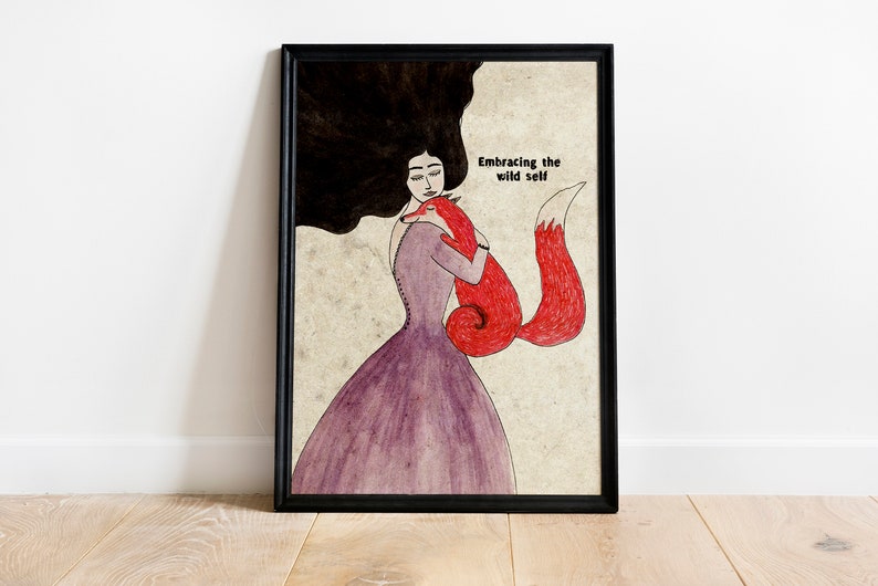 K&ouml;nnte beinhalten: Eine gerahmte Illustration einer Frau mit langen schwarzen Haaren, die einen roten Fuchs umarmt. Der Text "Embracing the wild self" ist oben im Bild in Schwarz geschrieben.