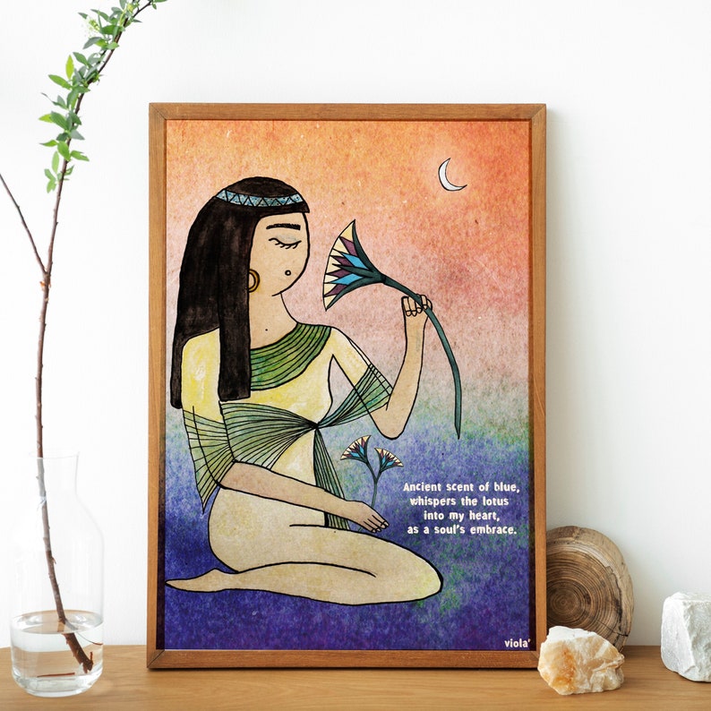 May include: A watercolor illustration of a woman with long dark hair wearing a yellow and green dress, sitting and smelling a blue and green lotus flower. The background is a gradient of orange, pink, purple, and blue. The text "Ancient scent of blue, whispers the lotus into my heart, as a soul's embrace. viola'" is at the bottom of the image.