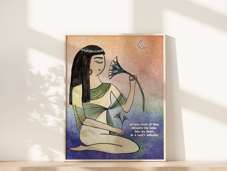 May include: A watercolor illustration of a woman with long black hair wearing a yellow and green dress. She is holding a blue lotus flower and looking at it. The background is a watercolor wash of orange, pink, and blue. The text "Ancient scent of blue, whispers the lotus into my heart, as a soul's embrace." is written in the bottom right corner.