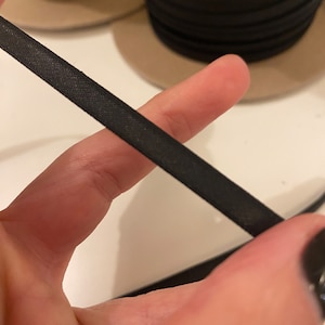May include: Black elastic band, a type of fabric used for sewing and crafting projects.