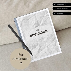 Può includere: Una penna stilo nera e grigia giace su un quaderno di carta bianca stropicciato con il testo "MY NOTEBOOK" sulla copertina. Il quaderno è per il reMarkable 2.
