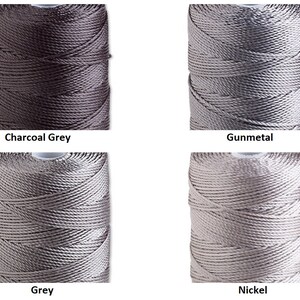 Peut inclure: Quatre bobines de fil de nylon dans diff&eacute;rentes nuances de gris. Les couleurs sont &eacute;tiquet&eacute;es : Gris charbon, Gunmetal, Gris et Nickel. Le fil est enroul&eacute; serr&eacute; sur des bobines, mettant en valeur la texture et l'&eacute;clat du mat&eacute;riau. Id&eacute;al pour l'artisanat et la bijouterie.