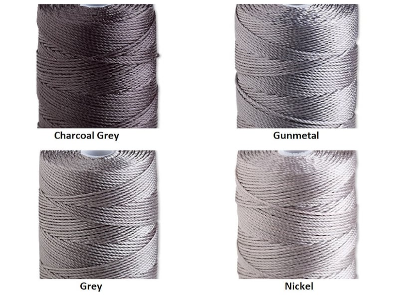 Peut inclure: Quatre bobines de fil de nylon dans diff&eacute;rentes nuances de gris. Les couleurs sont &eacute;tiquet&eacute;es : Gris charbon, Gunmetal, Gris et Nickel. Le fil est enroul&eacute; serr&eacute; sur des bobines, mettant en valeur la texture et l'&eacute;clat du mat&eacute;riau. Id&eacute;al pour l'artisanat et la bijouterie.