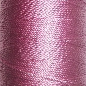 May include: Close-up of a spool of mauve-colored thread. The thread is tightly wound, showing a textured surface. The color transitions from a darker shade to a lighter hue, creating a gradient effect. Ideal for various crafting projects.