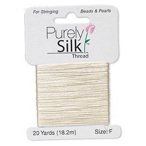 Op de afbeelding: Een spoel cr&egrave;mekleurig Purely Silk-garen, 18,2 meter, voor het rijgen van kralen. De draad zit op een witte kaart met de merknaam en een bloemenmotief. Maat F.