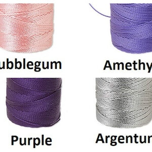 Peut inclure: Quatre bobines de fil color&eacute; sont pr&eacute;sent&eacute;es sur fond blanc. Les couleurs sont rose bubblegum, violet am&eacute;thyste, violet fonc&eacute; et argent argent&eacute;. Chaque bobine porte une &eacute;tiquette avec le nom de la couleur en gras noir.