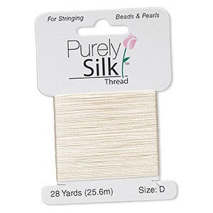 Op de afbeelding: Een spoel off-white Purely Silk-draad, ideaal voor het rijgen van kralen en parels. Het etiket geeft 25,6 meter draad, maat D aan. De verpakking is wit met de merknaam en een kleine bloemenafbeelding.