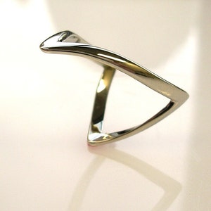 May include: A silver ring with a unique, twisted, triangular design.