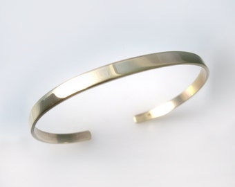 May include: A simple silver bangle bracelet with a smooth, polished finish.