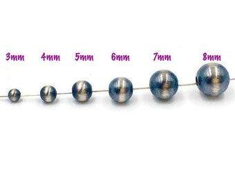 May include: A set of 6 silver-toned round beads with a black stripe, ranging in size from 3mm to 8mm. The beads are strung on a wire.