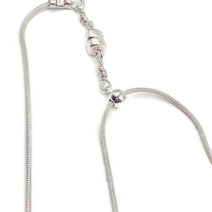 May include: A silver magnetic necklace with a snake chain style. The necklace has a magnetic clasp and a small silver bead.