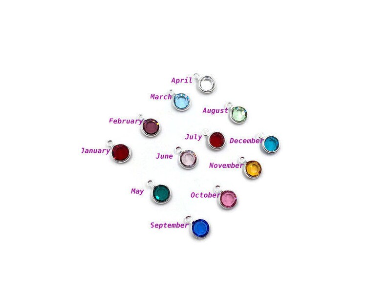 Pode incluir: Doze pingentes de prata com cristais coloridos, cada um representando um m&ecirc;s do ano. Janeiro &eacute; vermelho, fevereiro &eacute; roxo, mar&ccedil;o &eacute; azul, abril &eacute; azul claro, maio &eacute; verde, junho &eacute; verde claro, julho &eacute; rosa, agosto &eacute; verde claro, setembro &eacute; azul, outubro &eacute; rosa, novembro &eacute; laranja e dezembro &eacute; vermelho.