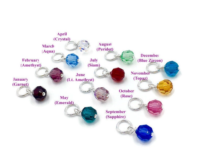 May include: Twelve silver charms with coloured glass beads, each representing a different month of the year. The charms are labelled with the month and the corresponding birthstone.