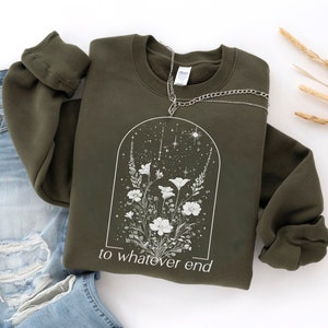 May include: A dark green sweatshirt with a white floral design and the text "to whatever end" printed on the front.