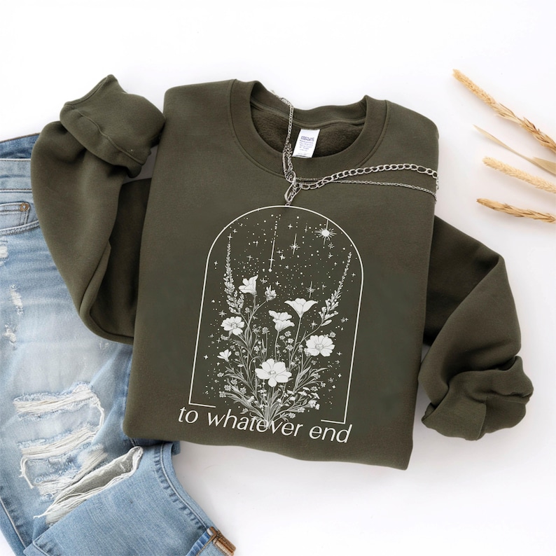 May include: A dark green sweatshirt with a white floral design and the text "to whatever end" printed on the front.