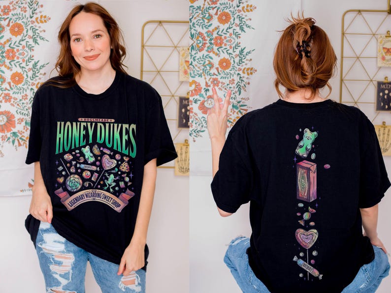 Może przedstawiać: Czarny t-shirt z napisem "Honeydukes" i grafiką cukierk&oacute;w. Prz&oacute;d przedstawia kolorowy wz&oacute;r r&oacute;żnych słodyczy, a tył ilustracje żelk&oacute;w i cukierk&oacute;w. Koszulka jest noszona przez osobę w niebieskich dżinsach.