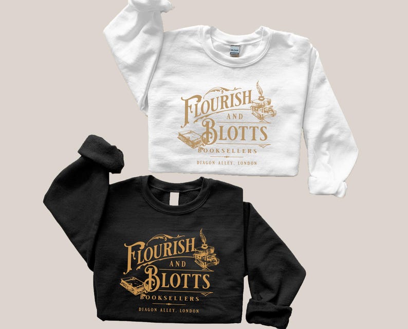 May include: Two sweatshirts with a gold graphic of the fictional bookstore "Flourish and Blotts" from the Harry Potter series. The text reads "Flourish and Blotts Booksellers Diagon Alley, London". One sweatshirt is white and the other is black.