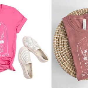 May include: Two t-shirts with a floral design and the text "to whatever end". The shirt on the left is pink and the shirt on the right is a dusty rose color.