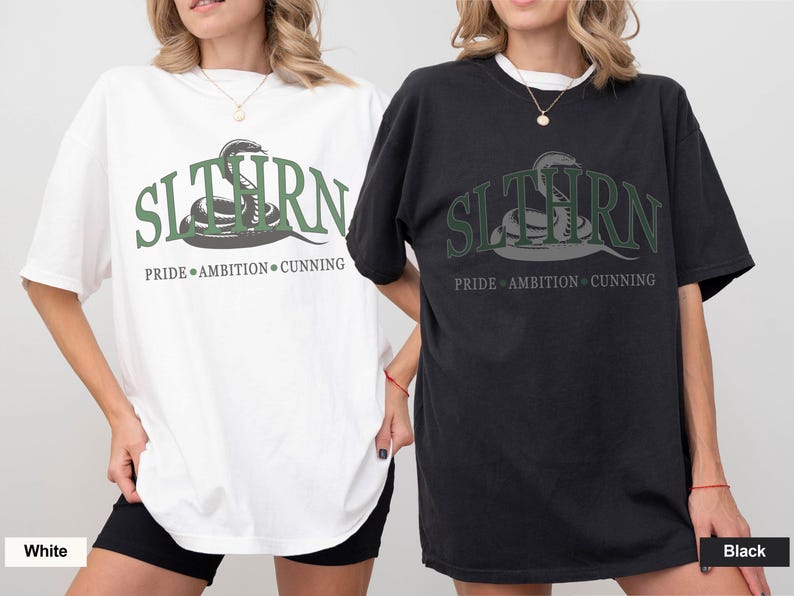 May include: Two oversized t-shirts with a snake graphic and the text "SLYTHERN PRIDE AMBITION CUNNING". One shirt is white and the other is black.