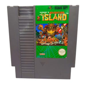 以下が含まれることがあります： グレーの任天堂エンターテインメントシステム（NES）ゲームカートリッジ。ラベルは緑色で、ゲームタイトル「Hudson's Adventure Island」が黄色と赤色で表示されています。アートワークは漫画のキャラクターとサイのような生き物を描いています。