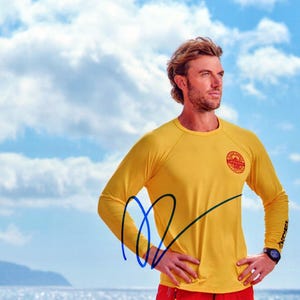 Adam demuestra en persona una foto firmada – RESCUE HI SURF
