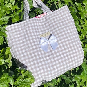 Bolso tote acolchado de cuadros vichy grises y cartera floral a juego. Conjunto de algodón hecho a mano. Forro rosa y detalle de lazo.