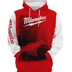 May include: Red and white hooded sweatshirt with the word "Milwaukee" in white script across the chest. The sleeves and hood are white, while the body is red with a faded image. The word "Milwaukee" is also printed on the left sleeve.