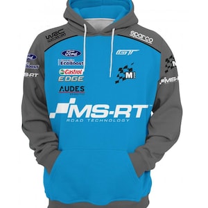 Puede incluir: Una sudadera con capucha azul y gris con varios logotipos, incluyendo "Ford" y "Castrol". La parte delantera es azul, con mangas y capucha grises. El texto "MS-RT ROAD TECHNOLOGY" está impreso en la parte delantera, junto con otros logotipos como "sparco" y "WEC".