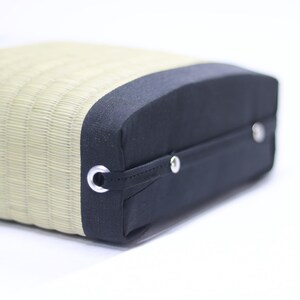 Angled front view of the Agura Tatami cushion.
The cushion’s sides are covered with black edge fabric, and a sturdy handle is securely stitched in place. Its practical design makes it easy to carry and store, while the precise craftsmanship is evident in every detail.