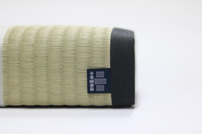 Rear view of the Agura Tatami cushion.
A brand tag from Koyanagi Tatami Shop, a heritage maker with over 150 years of history, is carefully sewn onto the black edge of the cushion—symbolizing both trust in craftsmanship and authentic Japanese quality. The meticulous attention to detail reflects a refined finish that combines the aesthetic of traditional Japanese design with everyday functionality.
