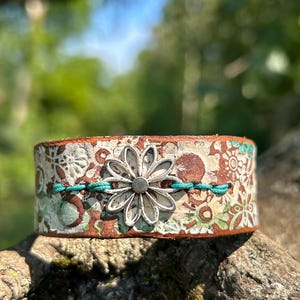 Pulsera de cuero hecha a mano: Margarita de peltre, ajustable, estilo bohemio.
