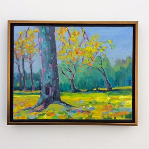 Puede incluir: Pintura al &oacute;leo de una escena de parque con &aacute;rboles y una zona de c&eacute;sped. Los &aacute;rboles tienen hojas amarillas y naranjas, y la hierba es de un verde-amarillo vibrante. El cielo es azul claro y la pintura est&aacute; enmarcada en un marco dorado.