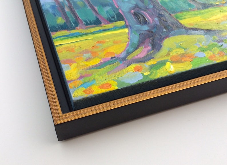 Puede incluir: Pintura al &oacute;leo de una escena de parque con &aacute;rboles y una zona de c&eacute;sped. La obra de arte est&aacute; enmarcada en un marco negro con un borde interior dorado. La pintura presenta colores vibrantes, incluyendo amarillo, verde y azul.