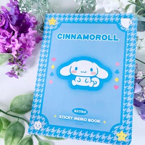 May include: A blue and white memo book with a cartoon dog on the front. The book says "Cinnamoroll Retro Sticky Memo Book" on the front.