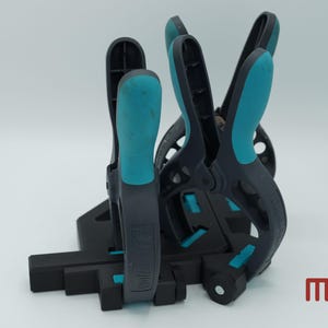 Può includere: Quattro morsetti d'angolo neri e blu con una base nera. I morsetti sono progettati per tenere i pezzi di legno ad un angolo di 90 gradi.