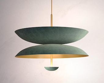 May include: A modern, three-tiered pendant light fixture with a green metal finish and a gold accent. The light is suspended from a single cord.