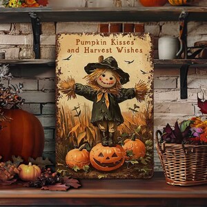 May include: A rustic metal sign with a scarecrow standing on a pumpkin, surrounded by other pumpkins and fall foliage. The sign reads "Pumpkin Kisses and Harvest Wishes". The scene evokes a cozy autumn theme.