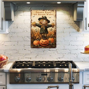 May include: A rectangular metal sign with a rustic design. The sign features a scarecrow standing on a carved pumpkin, with the text "Pumpkin Kisses and Harvest Wishes". The color palette includes orange, brown, and black.
