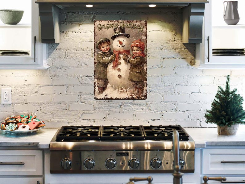 May include: A vintage-style metal sign with a Christmas theme. It features a snowman with two children, one on each side, and the text "Seasons Greetings".