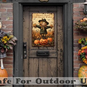 May include: A rustic metal sign with a scarecrow design and the text "Pumpkin Kisses and Harvest Wishes" hangs on a wooden door. The sign features a scarecrow standing on pumpkins. The scene is decorated with pumpkins and fall foliage.