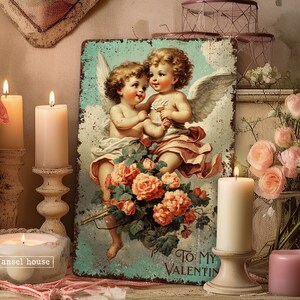May include: A vintage-style metal sign with a blue background featuring two cherubs with wings, holding a bouquet of pink roses. The sign reads "To My Valentine".