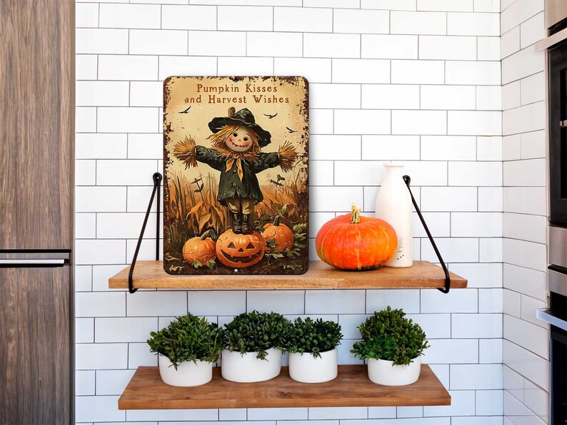 May include: A rectangular metal sign with the text "Pumpkin Kisses and Harvest Wishes" features a scarecrow standing on a carved pumpkin. An orange pumpkin and a white bottle sit on a wooden shelf. Below, are four white pots with green plants.