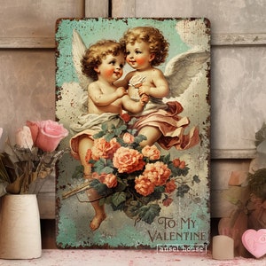 May include: Vintage-style metal sign featuring two cherub angels with wings, holding roses and a banner that reads "To My Valentine" with the text "[ansel house]" below. The sign has a distressed, aged look and is surrounded by a floral border.